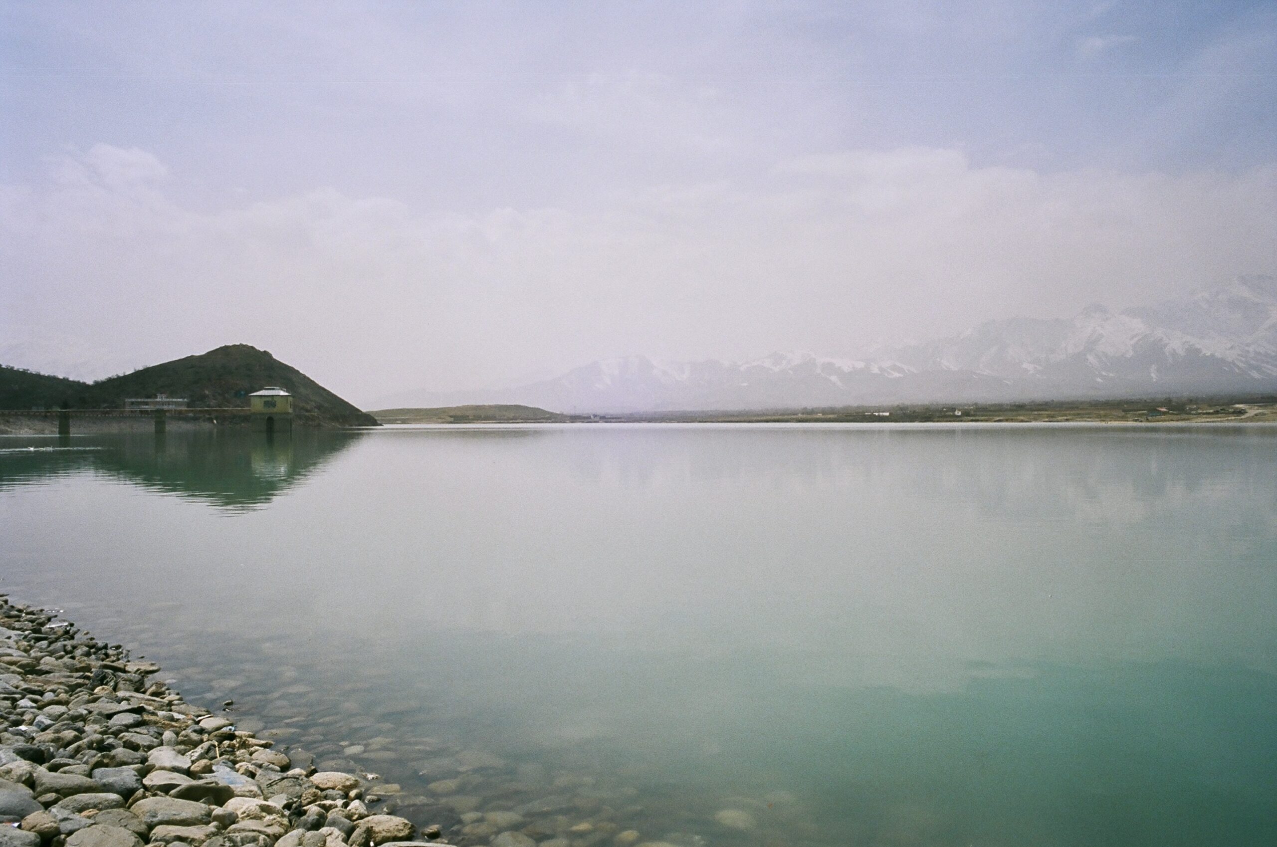 Bande Qargha Lake with ice capped mountains in the background.